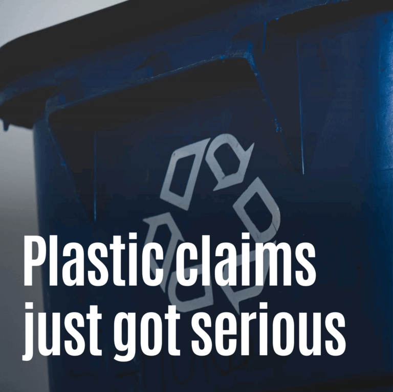 A close-up of a dark blue recycling bin with a white recycling symbol in the center. Overlay text in bold white letters reads: “Plastic claims just got serious.” The image conveys urgency and scrutiny around recyclability claims in plastic use.